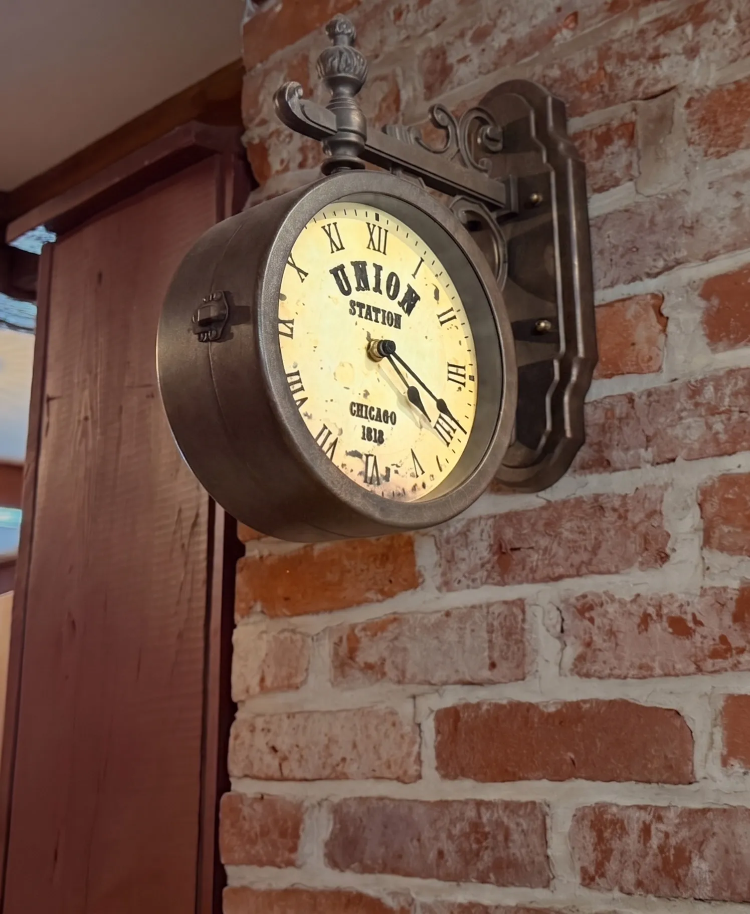Vintage Union Station Chicago double-sided clock mounted on the taproom brick wall